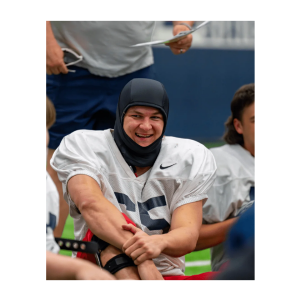 A smiling football player wearing a helmet, showcasing enthusiasm and readiness for the game ahead.