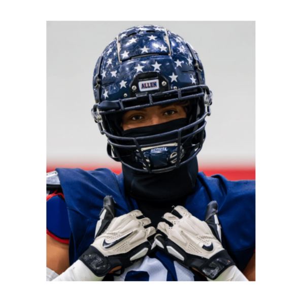 A football player in action, wearing a helmet decorated with stars, symbolizing pride and individuality on the field.